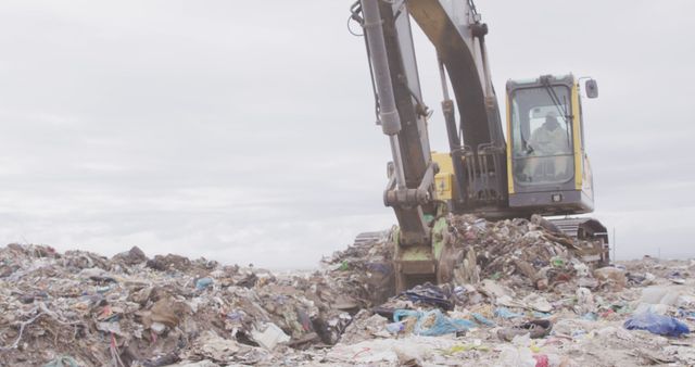 General view of landfill with piles of litter, worker and excavator. Landfill, waste, pollution and environment.
