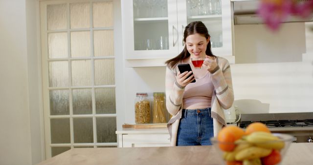 Young Woman Enjoying Morning Coffee and Browsing Smartphone in Modern Kitchen - Download Free Stock Images Pikwizard.com