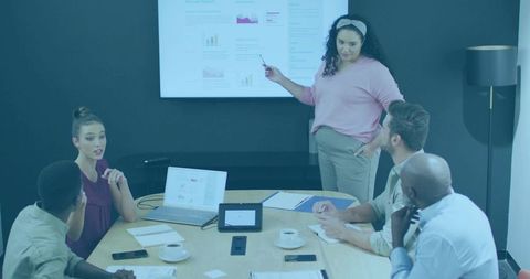 Woman presenting annual report to diverse team in modern boardroom with charts