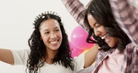 Joyful women celebrating at home party with colorful balloons