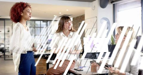 Women collaborating and brainstorming in modern bright open-plan office, casual business