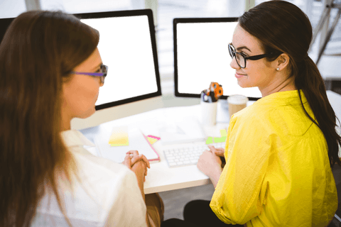 Two Businesswomen Engaged in Discussion at Transparent Workstations - Download Free Stock Videos Pikwizard.com