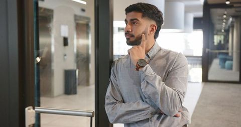 Confident Businessman Checking Time in Office Corridor