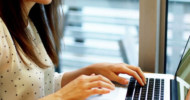 Woman Typing on Laptop by Window in Office - Download Free Stock Images Pikwizard.com