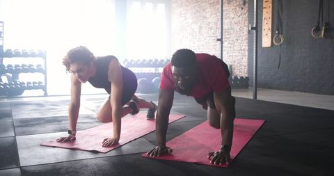 Diverse Couple Practicing Mountain Climbers in Modern Gym