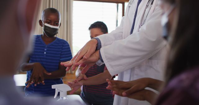 Doctor instructing group of children on effective hand sanitizing methods, promoting hygiene and infection control. Suitable for healthcare education materials, promoting hygiene awareness, or illustrating health and safety practices.