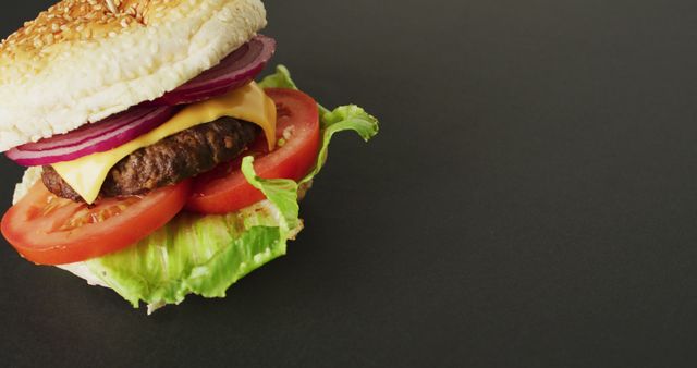 Delicious Cheeseburger with Lettuce, Tomato and Onion on Dark Background - Download Free Stock Images Pikwizard.com