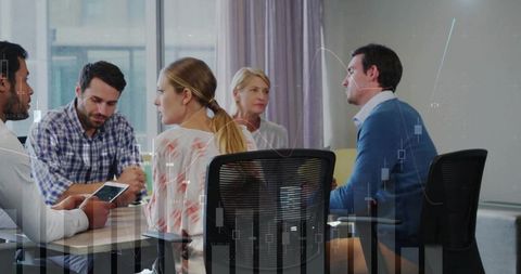 Coworkers discussing and analyzing financial data at conference table with charts overlay