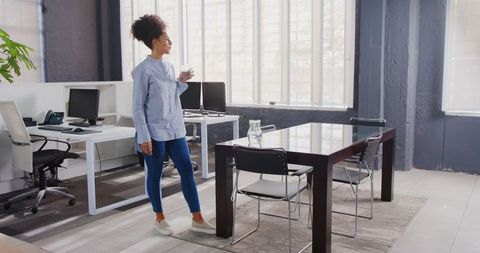 Smiling Businesswoman Holding Coffee in Bright Modern Office - Download Free Stock Images Pikwizard.com