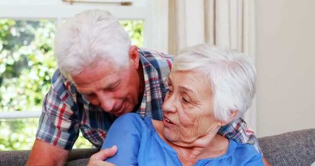 Senior couple talking in sitting room at home