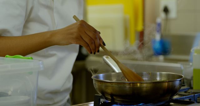 Chef Stirring Hot Meal in Kitchen with Wooden Spoon - Download Free Stock Images Pikwizard.com