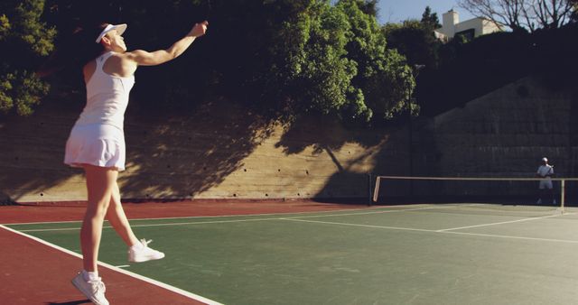 Determined Woman Serving Tennis Ball on Outdoor Court - Download Free Stock Images Pikwizard.com