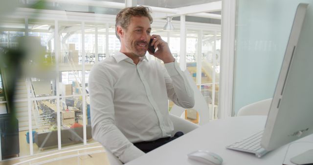 Businessman Talking on Phone at Modern Office Desk - Download Free Stock Images Pikwizard.com