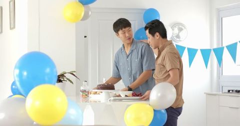 Two Friends Preparing for Birthday Celebration with Cake and Balloons