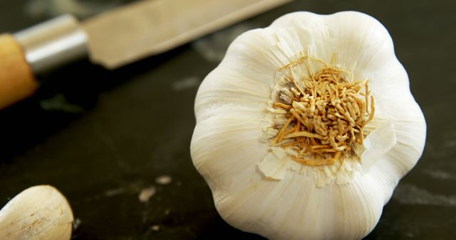 Fresh Garlic Bulb on Dark Surface with Knife - Download Free Stock Images Pikwizard.com