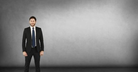 Confident Businessman Standing Against Gray Background - Download Free Stock Images Pikwizard.com