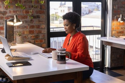 African American Professional Typing on Laptop in Urban Office