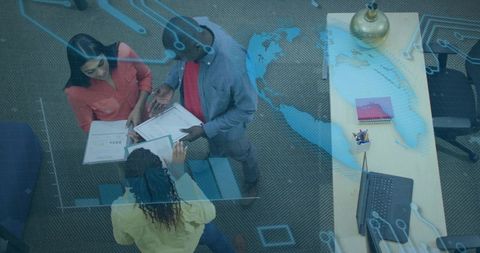Diverse team reviewing reports with global map overlay for data-driven collaboration