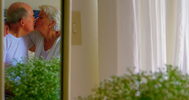 Caucasian senior couple kissing each other in bedroom at comfortable home - Download Free Stock Photos Pikwizard.com