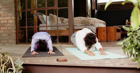 Diverse Women Practicing Yoga Child's Pose on Patio
