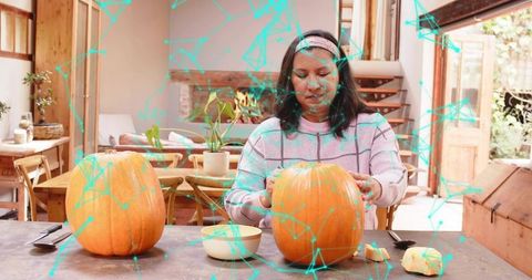 Mature woman carving pumpkins on rustic kitchen table with teal overlay for cozy fall DIY