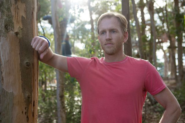 Man Standing in Forest Leaning Against Tree - Download Free Stock Images Pikwizard.com