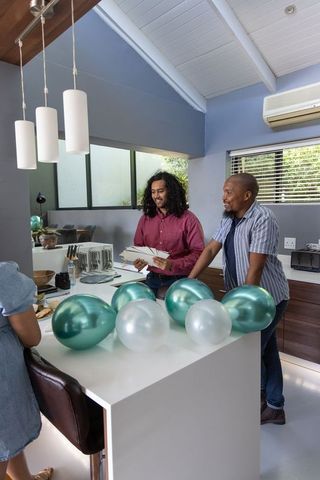 Friends preparing celebration with balloons and invitations at home