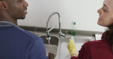 Happy Diverse Couple Enjoys Washing Dishes Together at Home