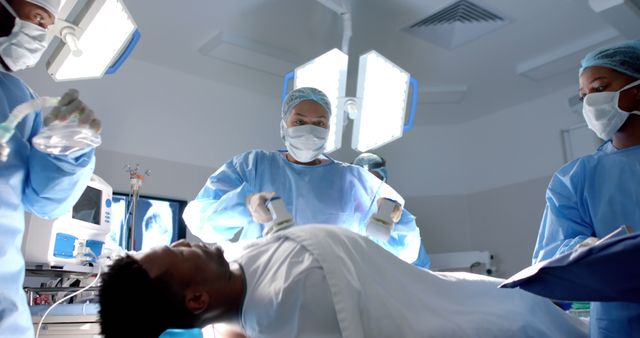Medical professionals performing life-saving surgery in an operating room. Ideal for use in healthcare, medical training, emergency services, and hospital-related content. Demonstrates teamwork and use of advanced medical technology.