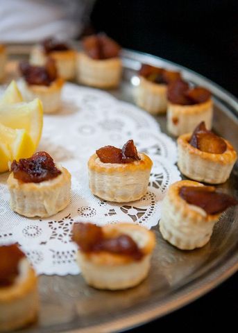 Gourmet tartlets with caramelized topping on decorative platter