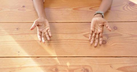 Open hands over wooden table conveying openness and collaboration