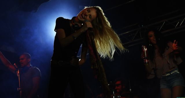 Energetic Woman Singing on Stage with Audience Cheering - Download Free Stock Images Pikwizard.com