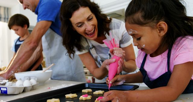 Parents and children baking and decorating cookies in kitchen. Great for usage in lifestyle, family bonding, cooking activities, and parenting contexts.