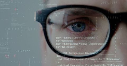 Focused developer analyzing code reflections behind glasses