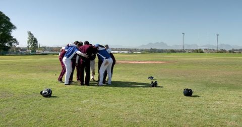 Male baseball team huddling for motivation on field