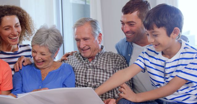 Extended Family Enjoying Old Photo Album Together in Living Room - Download Free Stock Images Pikwizard.com