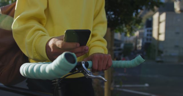 Person holding phone while standing next to bicycle handlebars - Download Free Stock Images Pikwizard.com