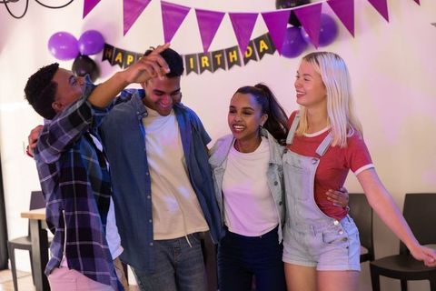 Joyful Friends Celebrating Birthday Under Colorful Decorations