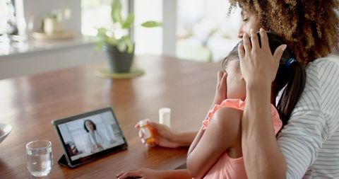 Mother and sick daughter video call virtual doctor assistance