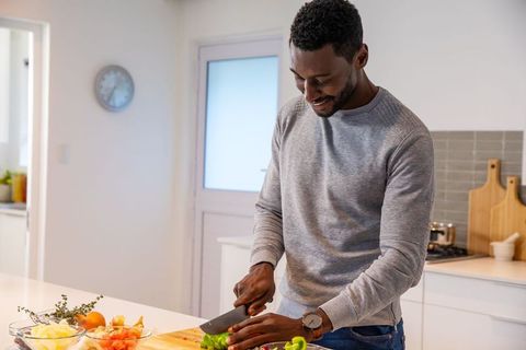 Man Slicing Green Bell Pepper in Modern Minimalist Kitchen