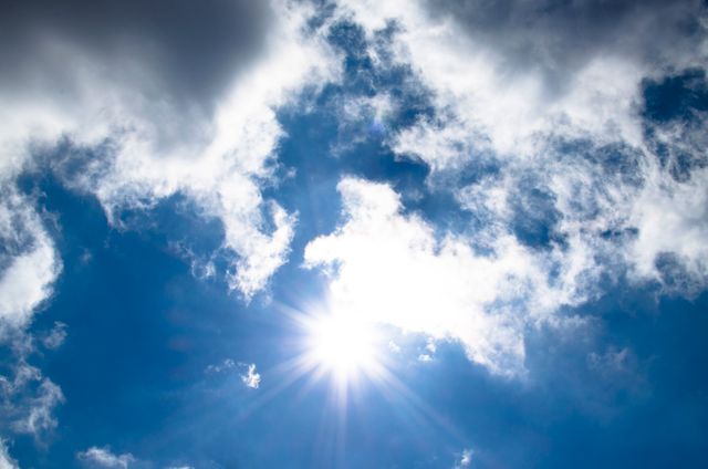 Bright sun shining through scattered clouds in blue sky - Download Free Stock Photos Pikwizard.com