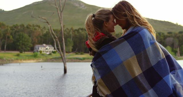Romantic couple head to head near lakeside. Couple wrapped in blanket 4k