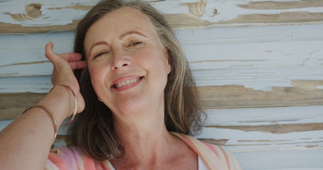 Smiling Middle-Aged Woman Relaxing by Weathered Wooden Wall - Download Free Stock Images Pikwizard.com