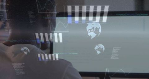 Back view of developer wearing light tee working with holographic analytics overlays on monitor