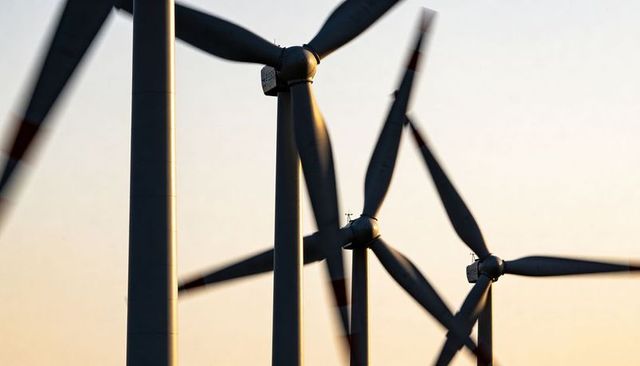 Wind Turbines Rotating at Sunrise on Open Plain with Blurred Blades and Warm Light