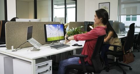 Asian Colleagues Exercising at Collaborative Office Desk