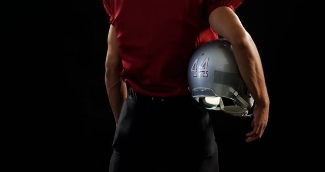 Football Player Holding Helmet Against Black Background - Download Free Stock Images Pikwizard.com