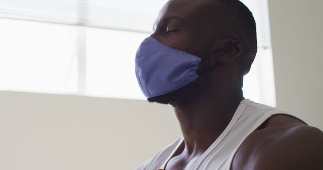 Man Meditating Wearing Face Mask in Sunlit Room - Download Free Stock Images Pikwizard.com