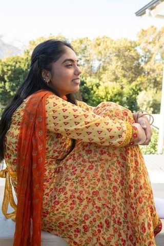 Indian Woman Relaxing on Porch in Vibrant Salwar Kameez