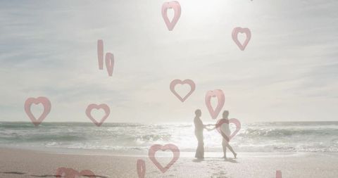 Romantic Senior Couple Walking Hand in Hand on Beach with Heart Overlay